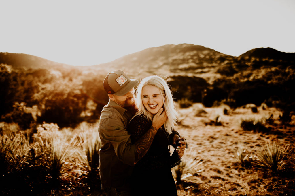 man hugging woman around her waist during Texas engagement photo shoot