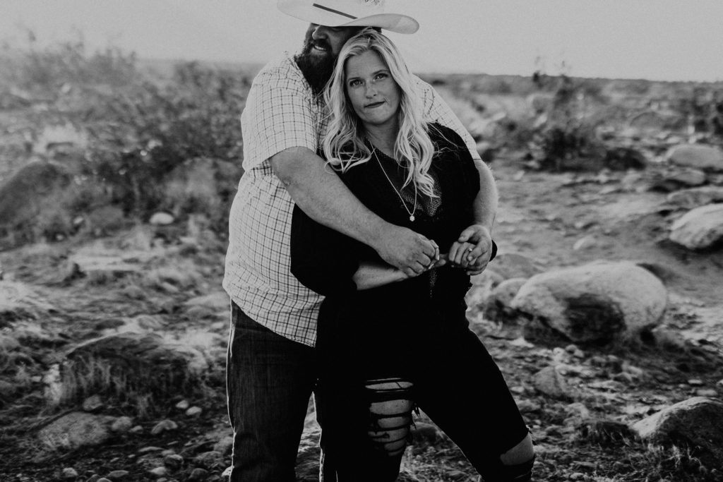 black and white photo of couple taking desert engagement photos