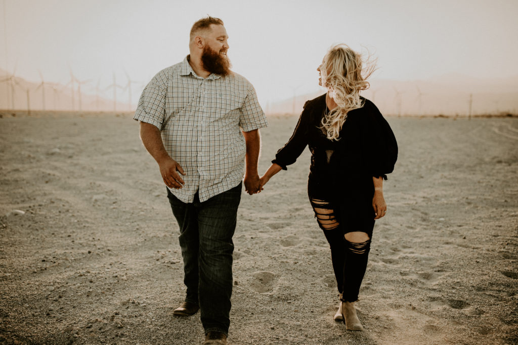 desert engagement photos in front of windmills