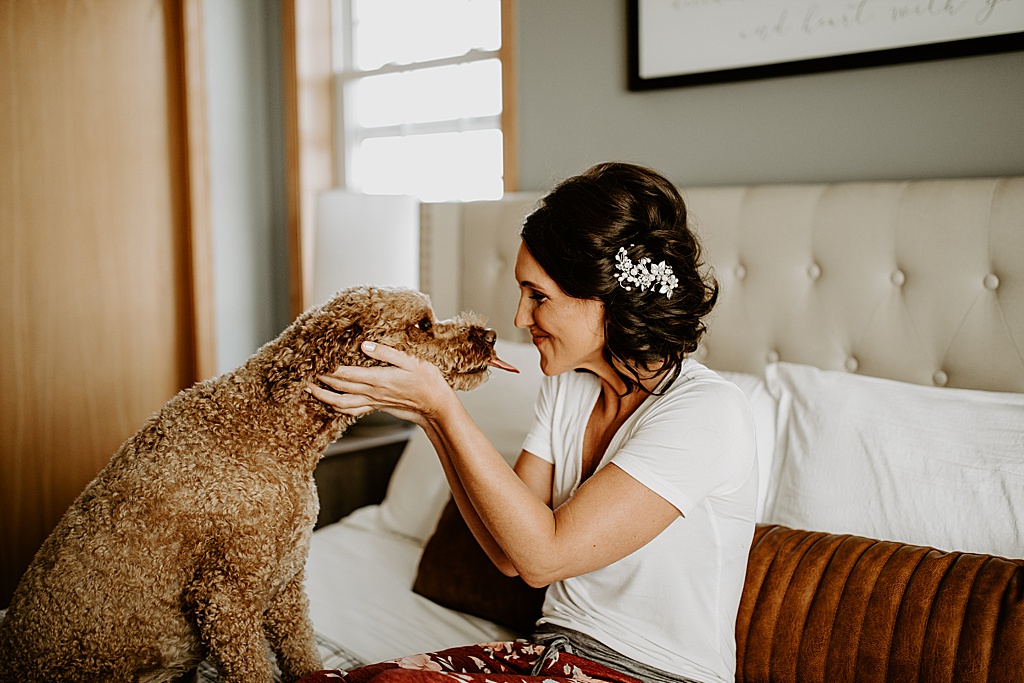bride gets a kiss from her dog before wedding