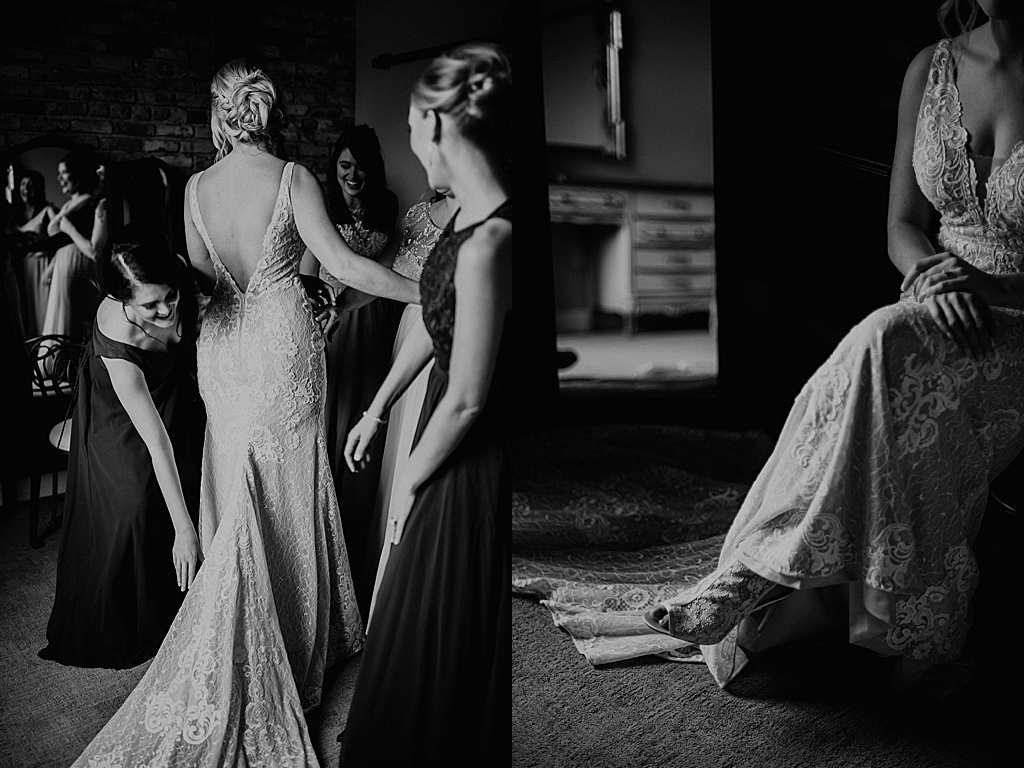 black and white photo of bridesmaids fixing brides dress before walking down the aisle