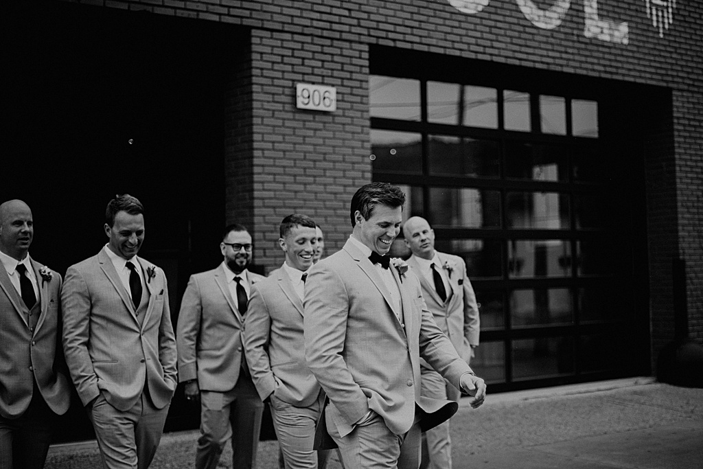 black and white photo of groom and groomsmen walking together