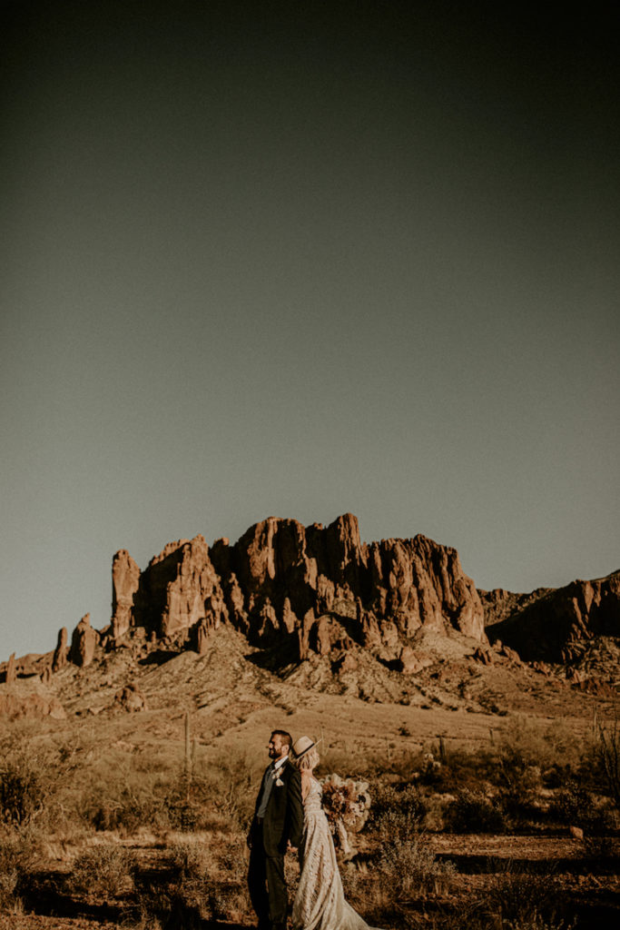 bride and groom standing in front of Arizona rock at elopement