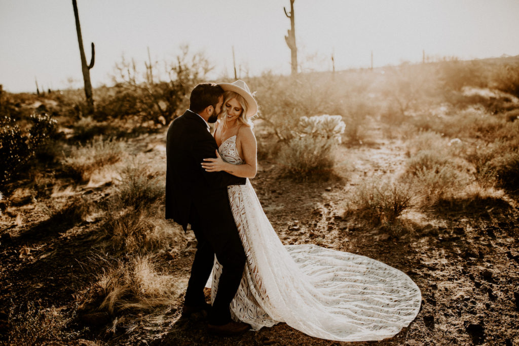 bride and groom hugging in Arizona desert