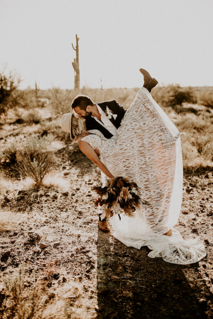groom dipping bride in Arizona desert boho style