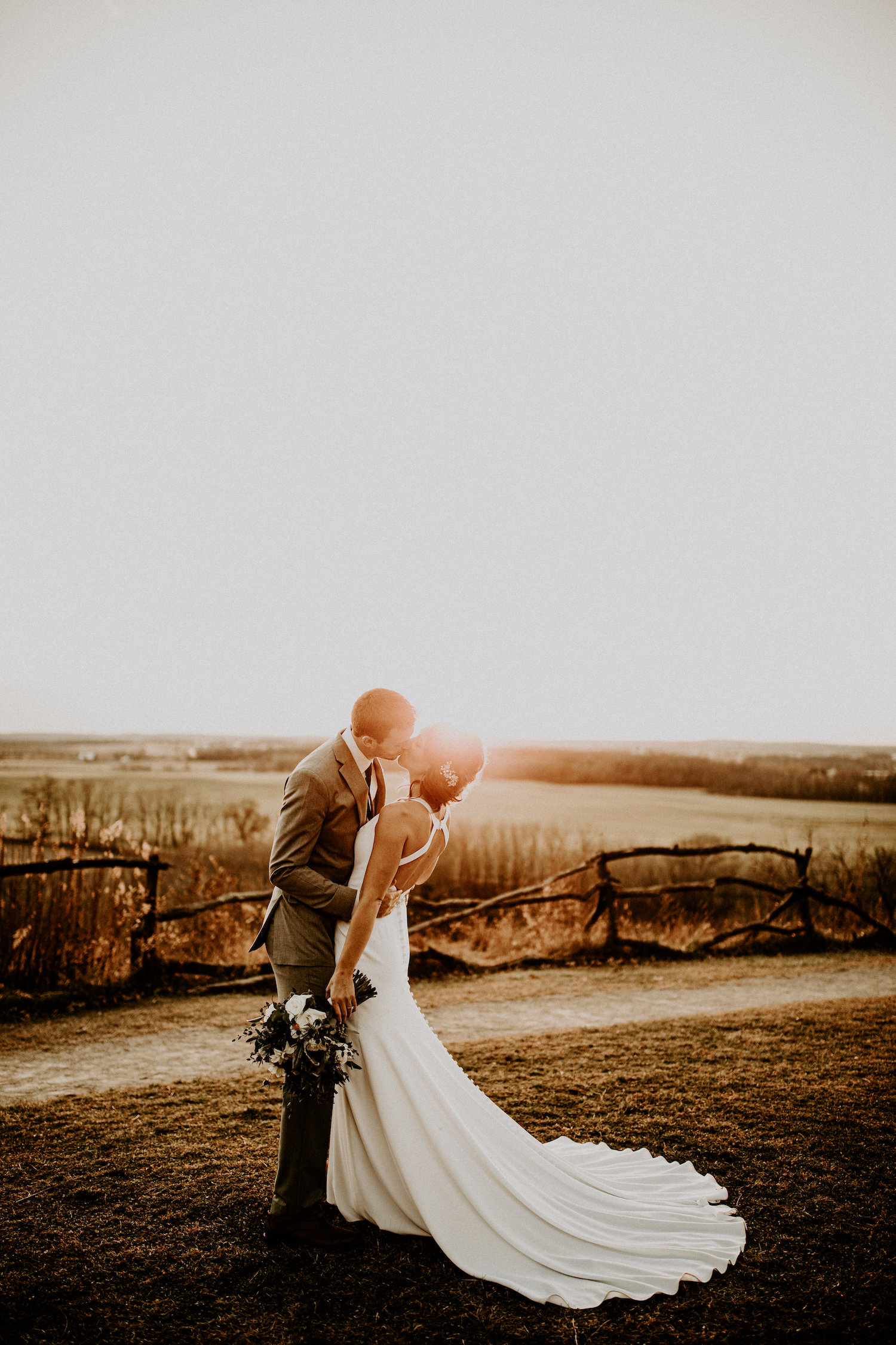 bride and groom during sunset photos kissing